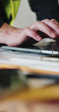 Laptop, man and hands of civil engineer in office typing for material delivery for renovation. Computer, industry and construction worker with online research for building plan with repairs on site.