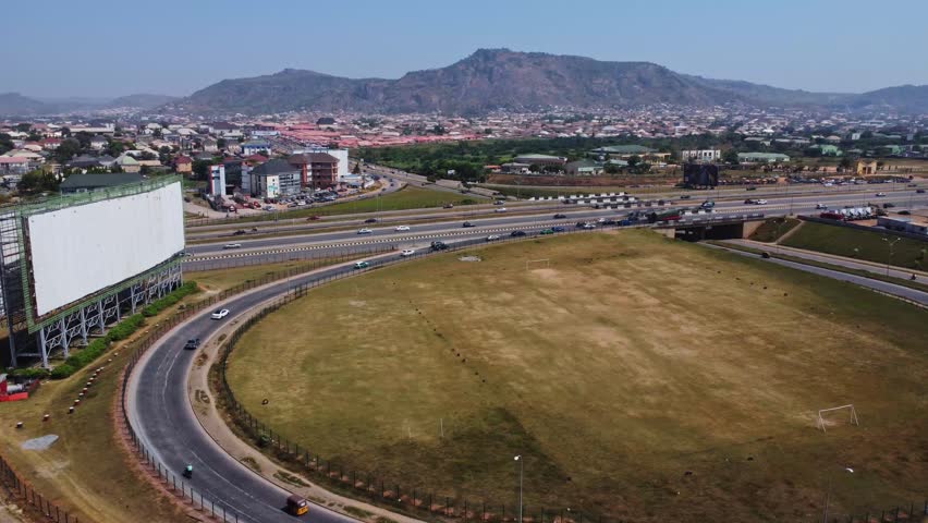 Beautiful high angle pan from a busy highway towards a wealthy suburban neighborhood in Abuja, Nigeria