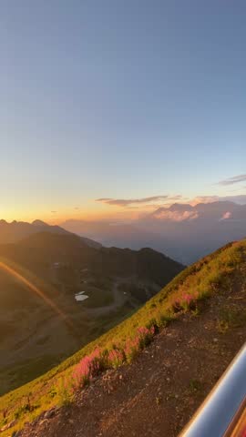 Golden sunset over mountain landscape with dramatic clouds and soft sunlight. Scenic panoramic view with warm evening light, peaceful nature and travel atmosphere.
