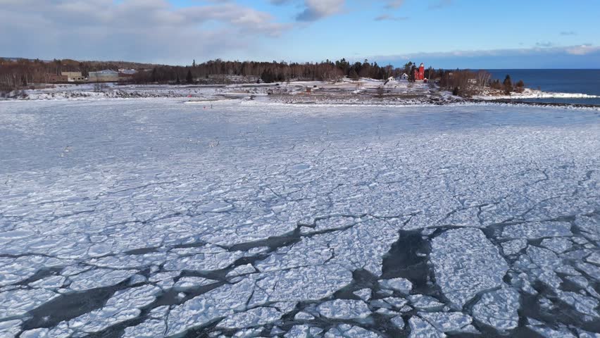 Group of birds flying over frozen lake with beautiful ice formations in Lake Superior, North Shore, Two Harbors Minnesota