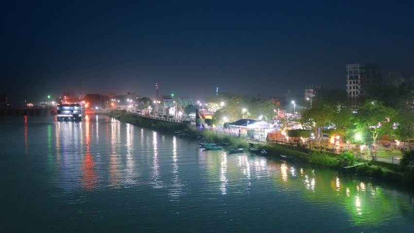 A scenic night view of a river cruise ship docked along the Nile River in Luxor, Egypt, with city lights reflecting on the water.