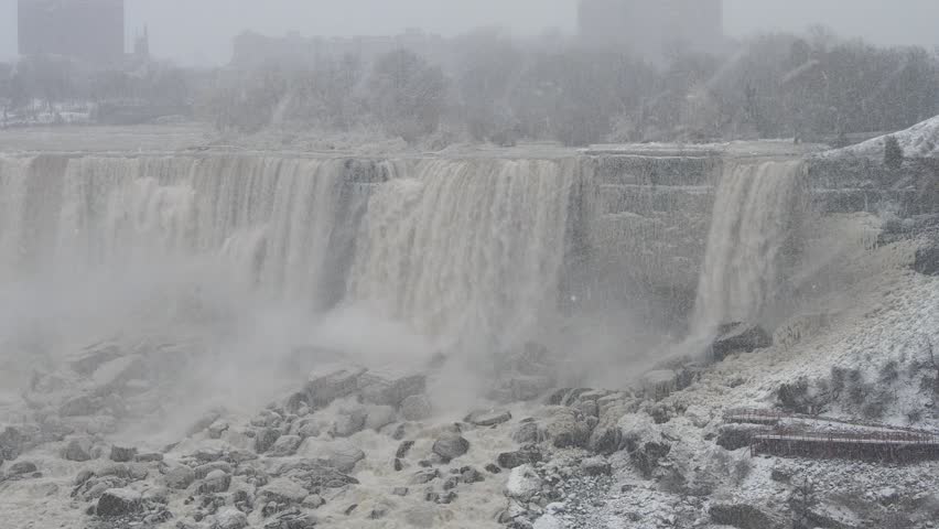 Wide winter view of Niagara Falls in snowfall and mist