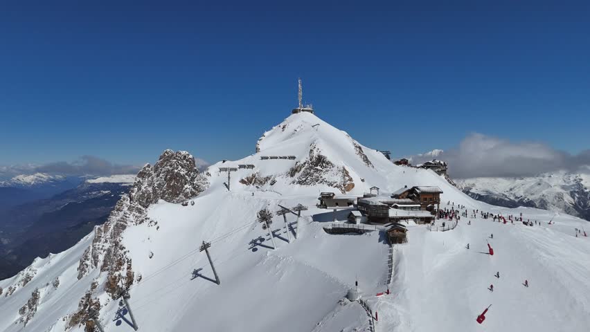 Aerial view of Courchevel and Meribel station in French alps with skiers on the slopes and snowcapped mountains by winter