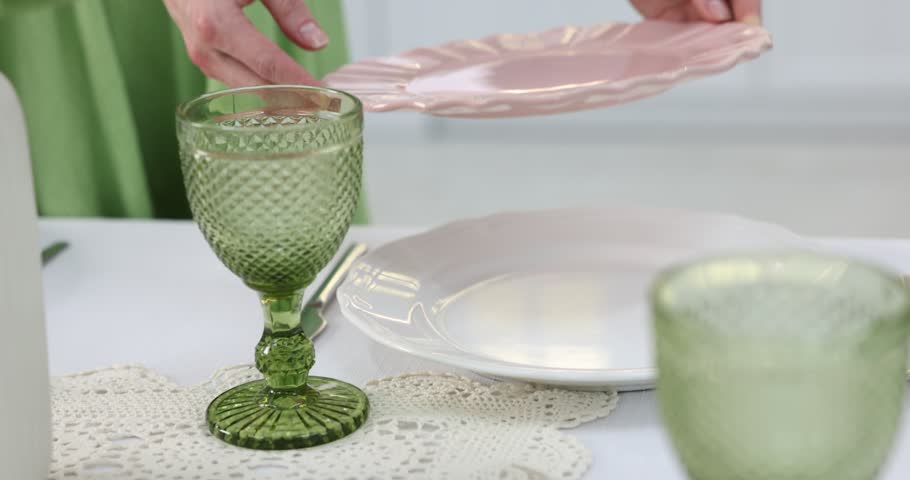 Woman setting table for dinner at home, closeup. Camera moving forward