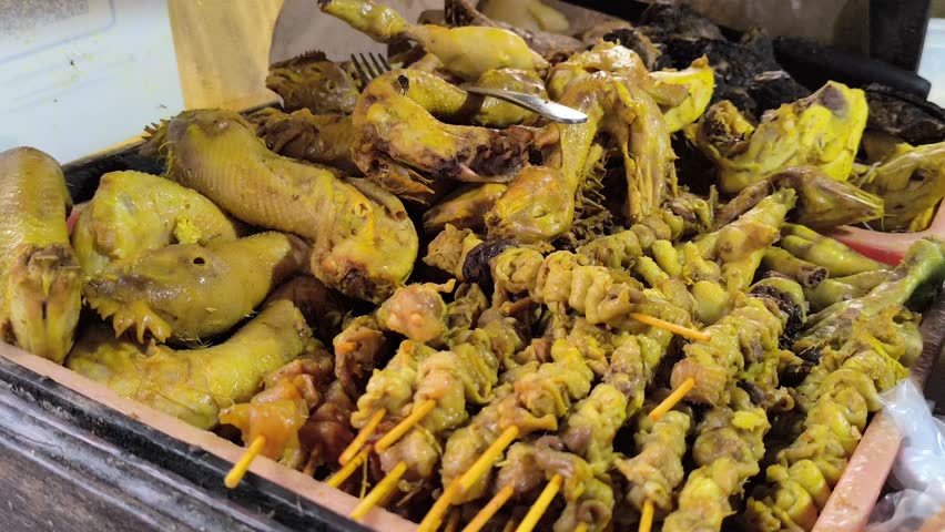 Assorted Yellow Spiced Chicken Giblets, Intestines, and Heads on Display
