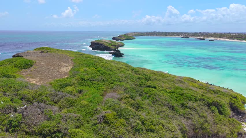 Aerial view of turquoise ocean water and rocky islands with green vegetation along the coast of Watamu Beach, Kenya.