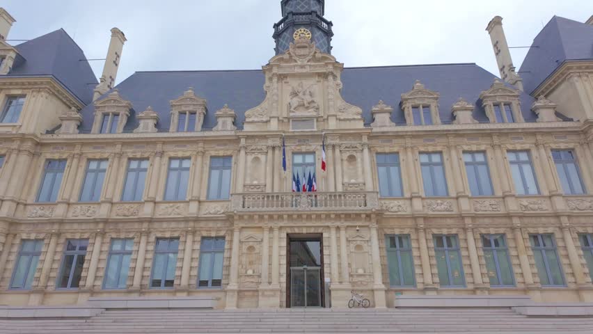 Reims, France, August 23rd, 2025, Reims City Hall (Hôtel de Ville) in France. Slow zoom establishing shot of the historic government building facade with French and EU flags.