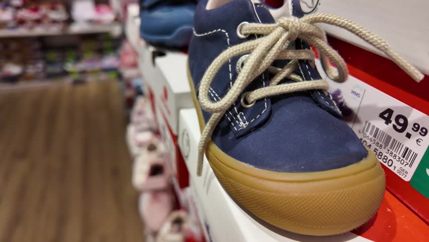 Close up of kids first walking shoes displayed on store shelf. Retail shopping concept, baby products, and children footwear selection in modern shop environment