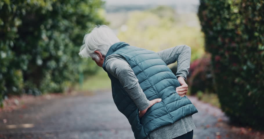 Senior, woman and back pain with fitness injury for workout accident or overworked strain in nature. Elderly, female person or runner with sore spine or joint inflammation for fibromyalgia or tension