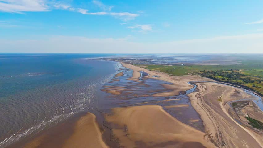 English Coastal Scene. Wide beaches Lincolnshire coast. Aerial video footage showing the north sea and east coast. Gibraltar Point National Nature Reserve near Skegness. Natural untouched landscape.