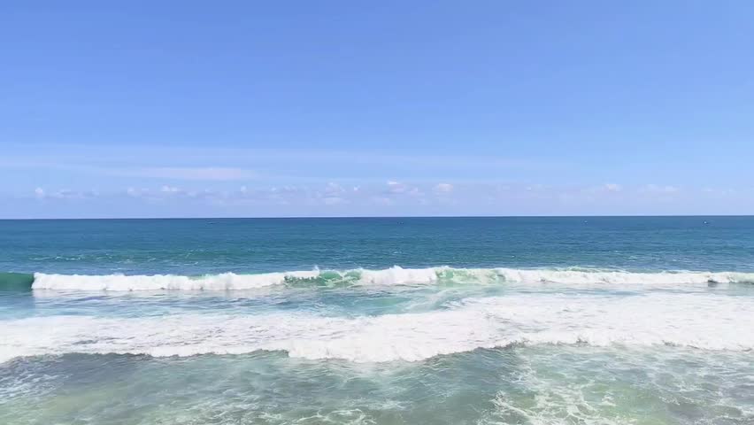 Waves crashing against a clear blue sky on the south coast of Java, Indonesia. Watu Lawang Beach, Gunungkidul, Indonesia