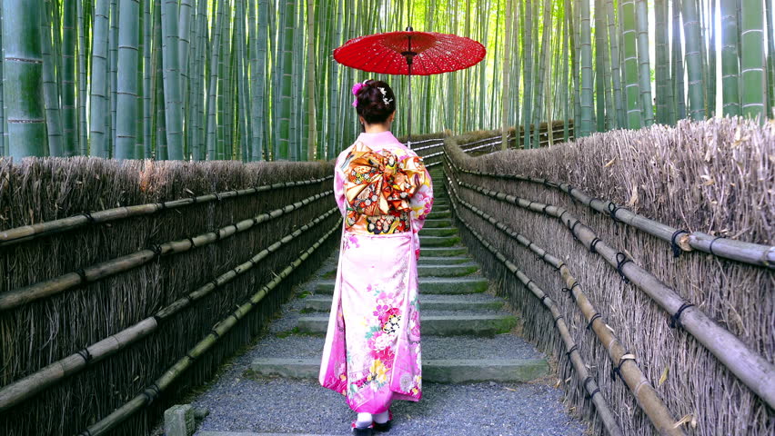 Asian woman wearing japanese traditional kimono at Bamboo Forest in Kyoto, Japan.