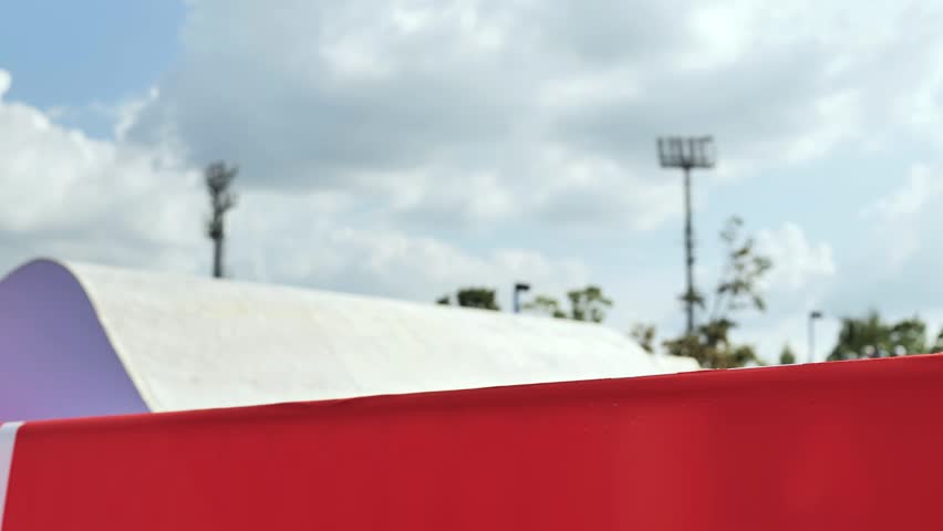 Person performing extreme scooter trick mid-air during outdoor skate park session