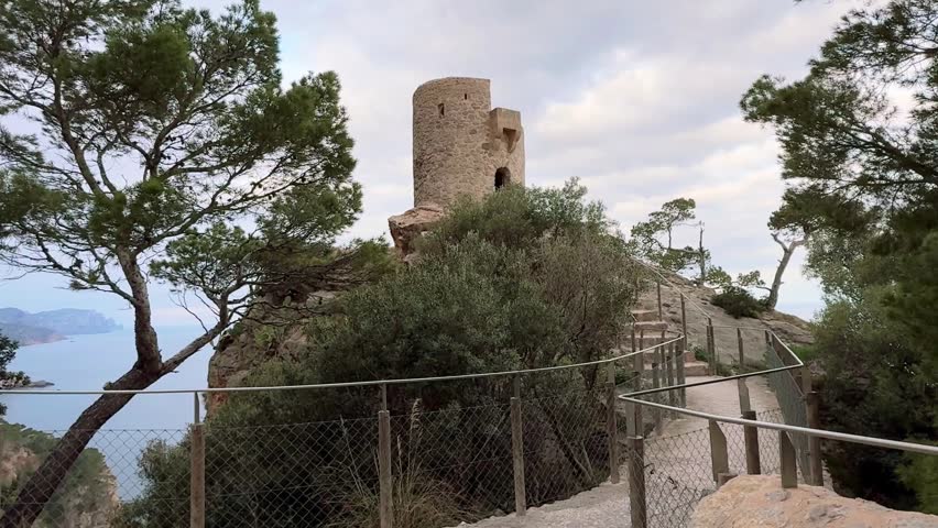 Man in Beanie and Hoodie Looking at Torre des Verger Watchtower in Mallorca