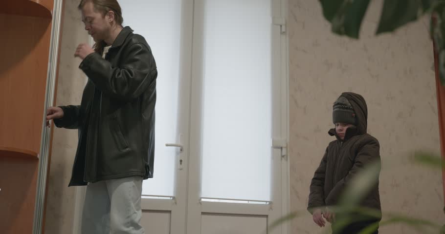 Man and child put on footwear winter shoes. 4K 10-bit