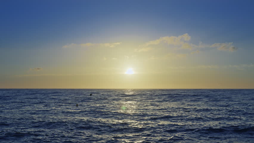 mesmerizing sea with soft waves at sunrise with sun coming up over the horizon