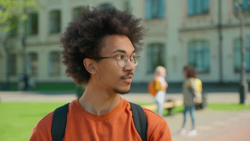 Happy smiling African American male student looking at camera university outdoor background students talk campus satisfied man positive ethnic guy portrait education learning study college high school