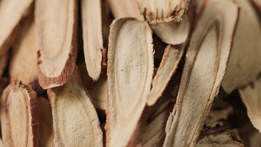 Extreme macro of licorice root slices, focusing on circular cross-sections and fine internal grain. Strong texture detail makes it ideal for background or visual layering.