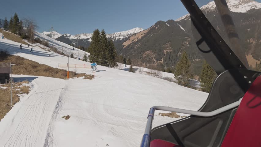 View from a chairlift of skiers on the slopes of the Zugspitz Arena in winter. Shot on a smartphone.