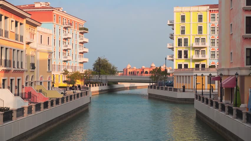 Picturesque canals of Qanat Quartier at The Pearl-Qatar, Doha. Venetian-inspired architecture with pastel buildings, arched bridges,