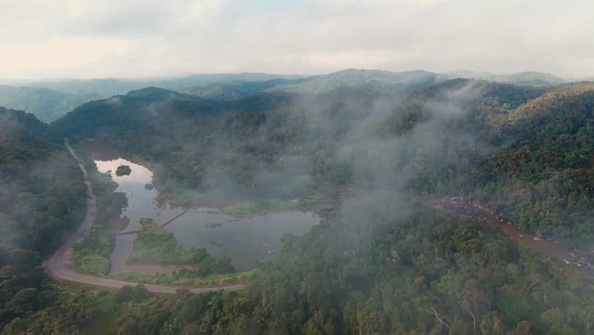 Aerial drone shot of the Ranomafana River flowing through the misty Madagascar jungle landscape