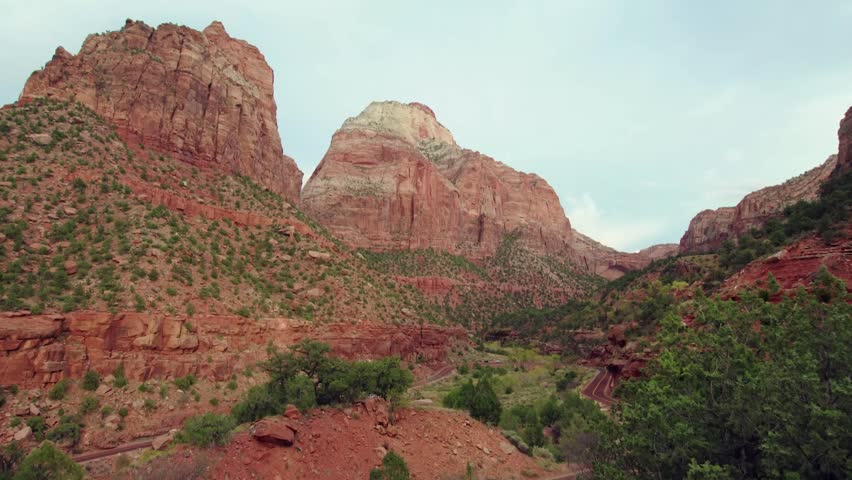 A sweeping canyon panorama reveals the majestic landscape of Zion National Park in southwestern Utah, near Springdale. The footage captures the grandeur of nature, featuring towering cliffs made of Na