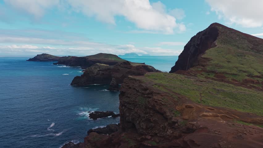Aerial view of rugged volcanic cliffs at Ponta de São Lourenço on Madeira island, textured terrain and Atlantic Ocean stretching into the horizon.