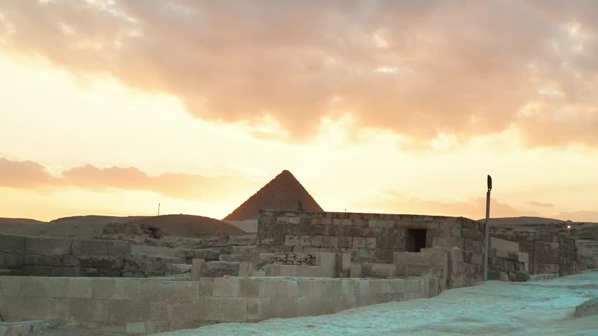 The beautiful sunset view of the great pyramid of giza at egypt on a dusk day and golden  sky in the middle of desert