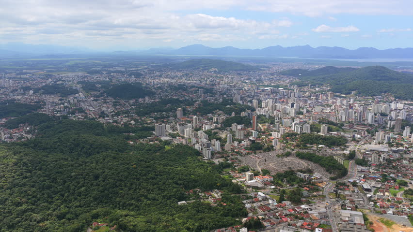 Wide aerial view of Joinville city with urban area, forest and Babitonga Bay in southern Brazil.