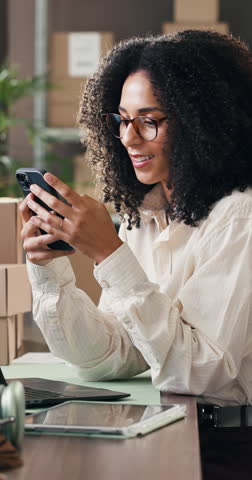 Boxes, phone and smile with woman in logistics plant for management of shipping schedule. Computer, text message and typing with employee person in supply chain office for delivery or distribution