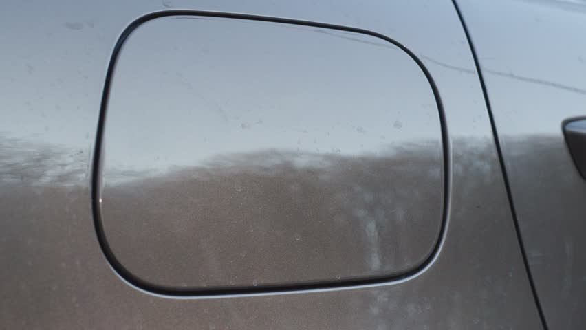Person opening a diesel car fuel tank cap