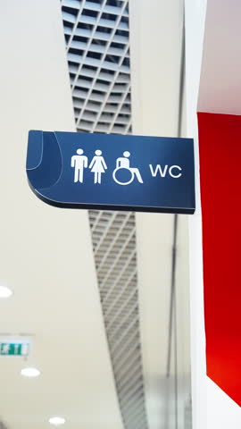 Modern wall-mounted restroom sign with male, female, and wheelchair accessibility icons next to 