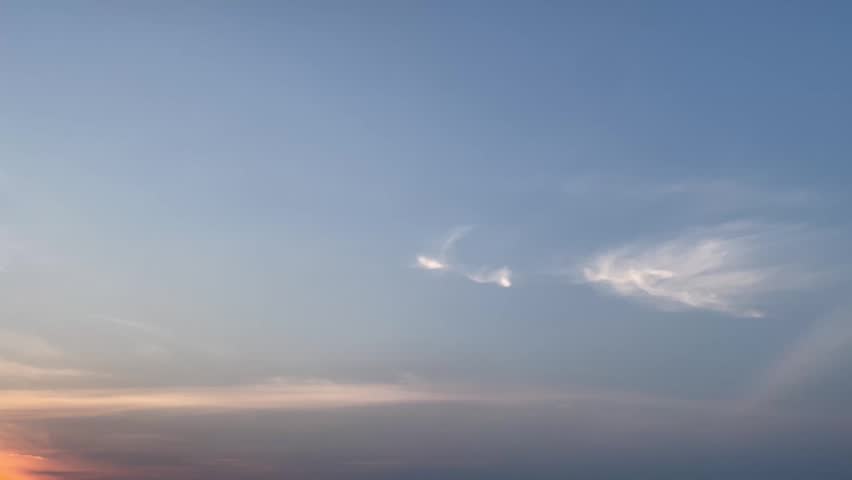 serene blue sky with clouds at sunset over the ocean