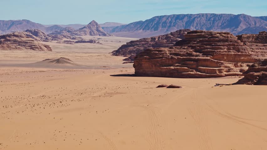 Side Drone over sandy desert with big rocky mountains in wadi rum in jordan