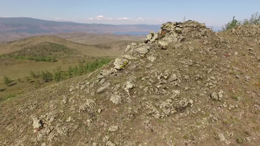 Panoramic view of hilly terrain with forest near the lake