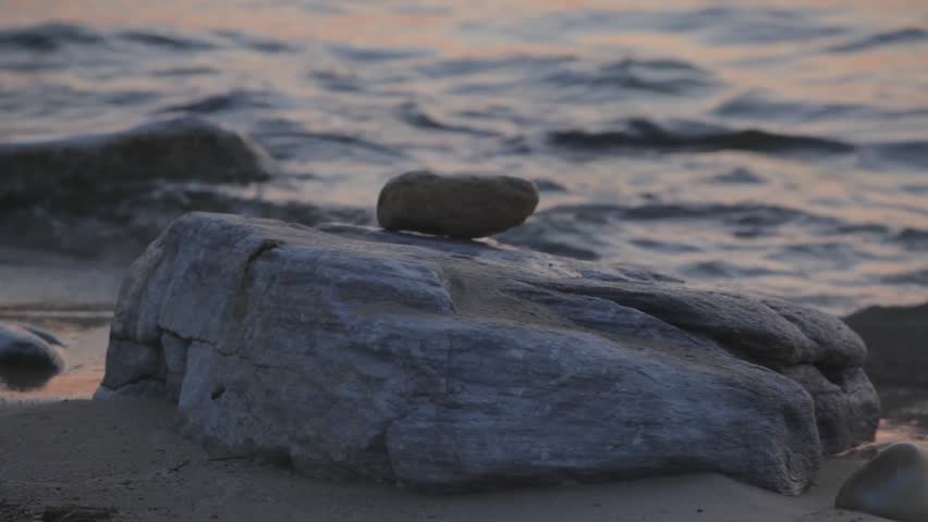 A large rock against the background of waves on the water