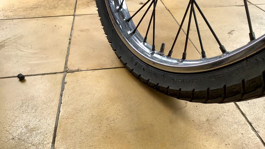 Man inflating motorcycle tire with manual portable hand pump. bike equipment.