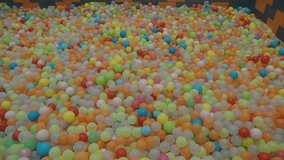 High angle shot of vibrant multicoloured plastic spheres filling playground ball pit. Child friendly play area footage. - Powered by Shutterstock - Get 15% off with code: PIKWIZARD15