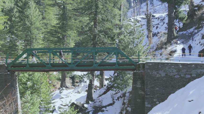 Group of Friends Crossing Snowy Bridge on Trail to Temple in Jammu and Kashmir, India