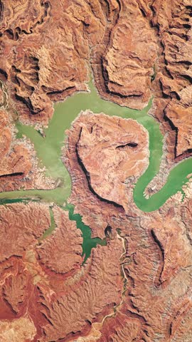 Panoramic top view of river in canyon among orange rocks in dry area. Camera is zooming in, rotating clockwise. Vertical video. Animation based on image by NASA
