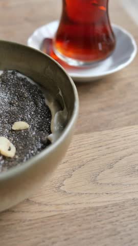 Close up view of healthy breakfast with chia seed pudding, fresh strawberries, banana slices, and various nuts on table. Cinematic dynamic motion.
