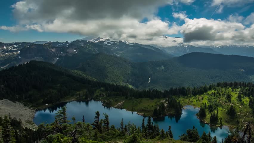 time-lapse video capturing the majestic Mount Rainier and the serene Eunice Lake in Mount Rainier National Park, Washington, USA. The footage showcases a beautiful, natural landscape with a snow-cappe