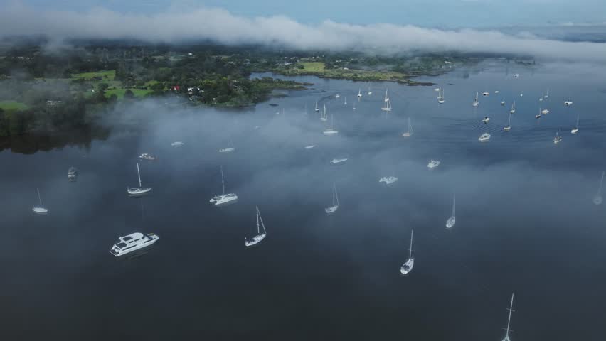 Calm harbor with anchored boats in morning fog Kerikeri Inlet Bay of Islands New Zealand
