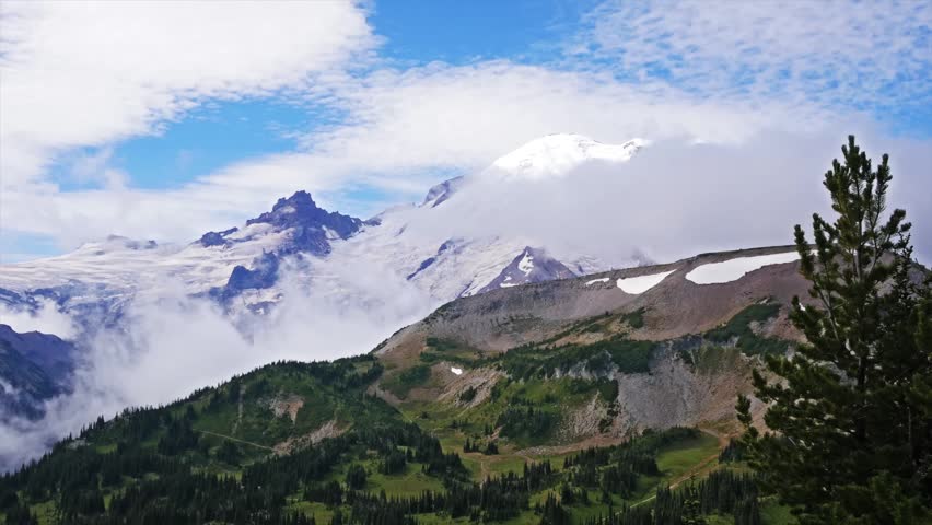 footage captures the iconic, snow-capped peak of Mount Rainier towering above the Cascade Range, as seen from the scenic Mount Fremont Lookout Trail in Mount Rainier National Park, Washington.