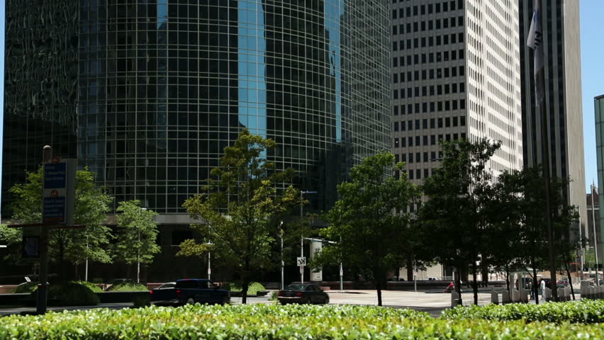 Traffic drives down Louisiana Street, downtown Houston between skyscrapers and rows of trees