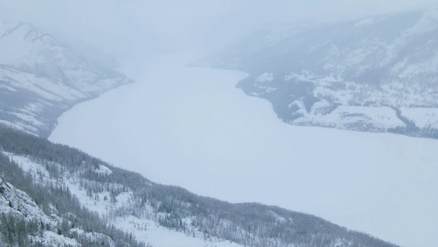 Snow-Capped Mountain Peaks Shrouded in Dense Fog on a Cold Winter Day