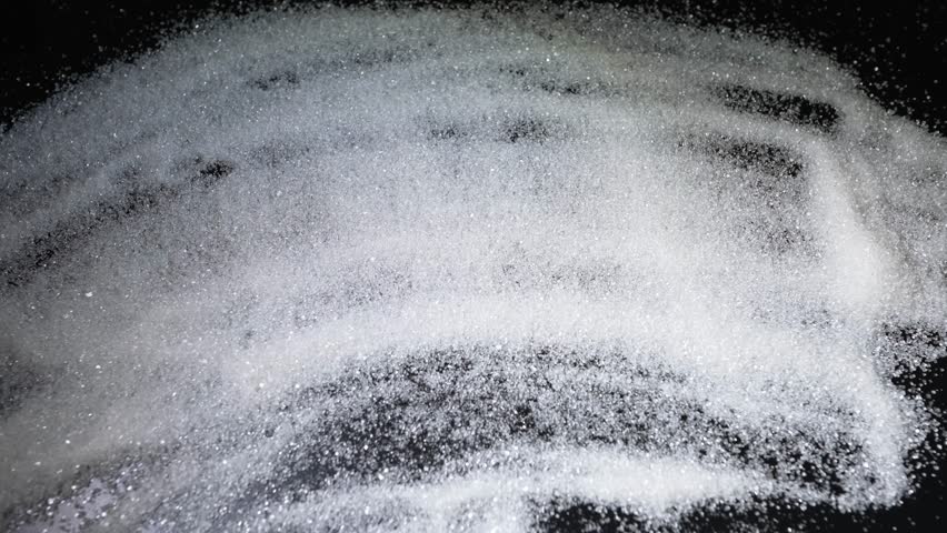 Man writing word sugar with finger on sugar covered table 