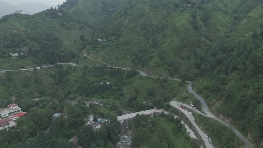 Breathtaking landscape of a wild river cutting through deep mountain valleys under a clear blue sky in Pakistan.