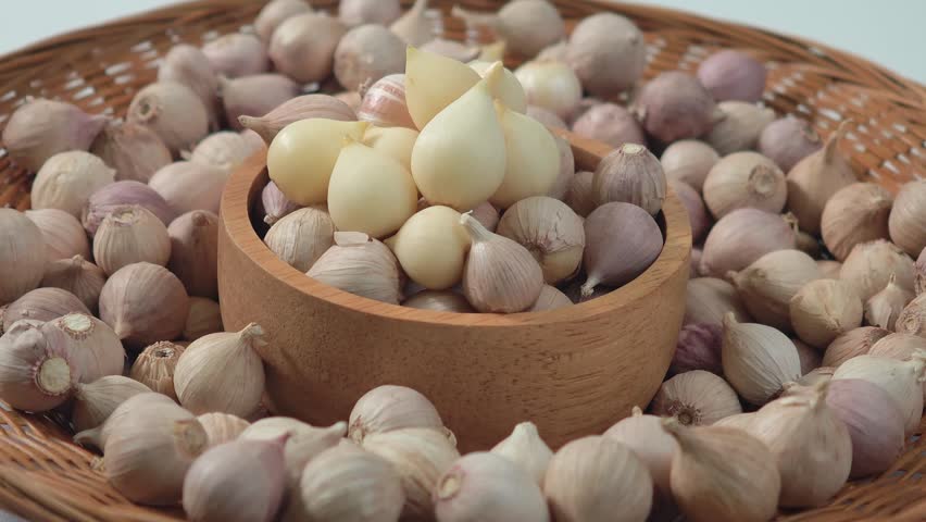 Single clove garlic in a wooden cup.