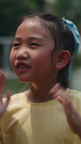 Young girl cheerfully singing and dancing outdoors on a sunny day